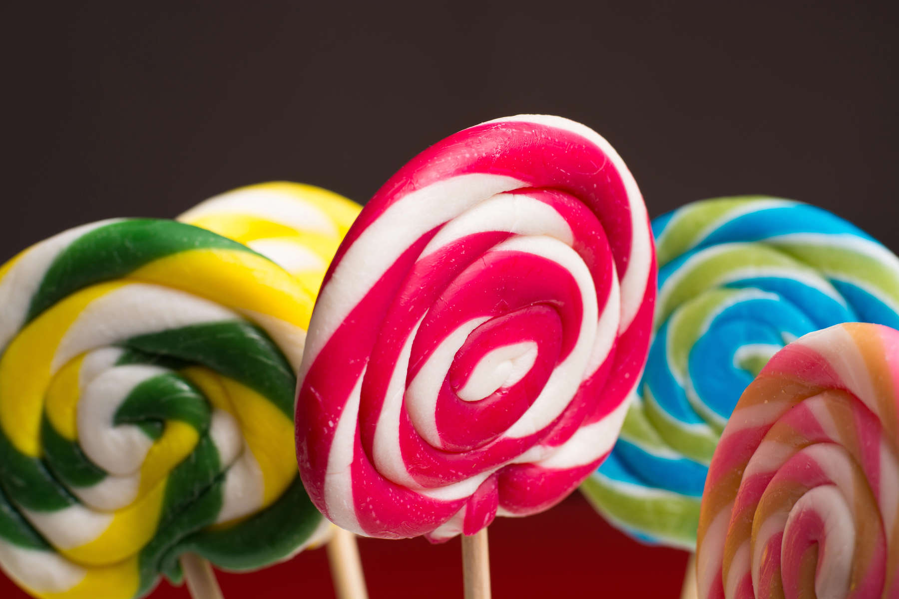Multicolored sweet candy canes and twirls on wooden sticks