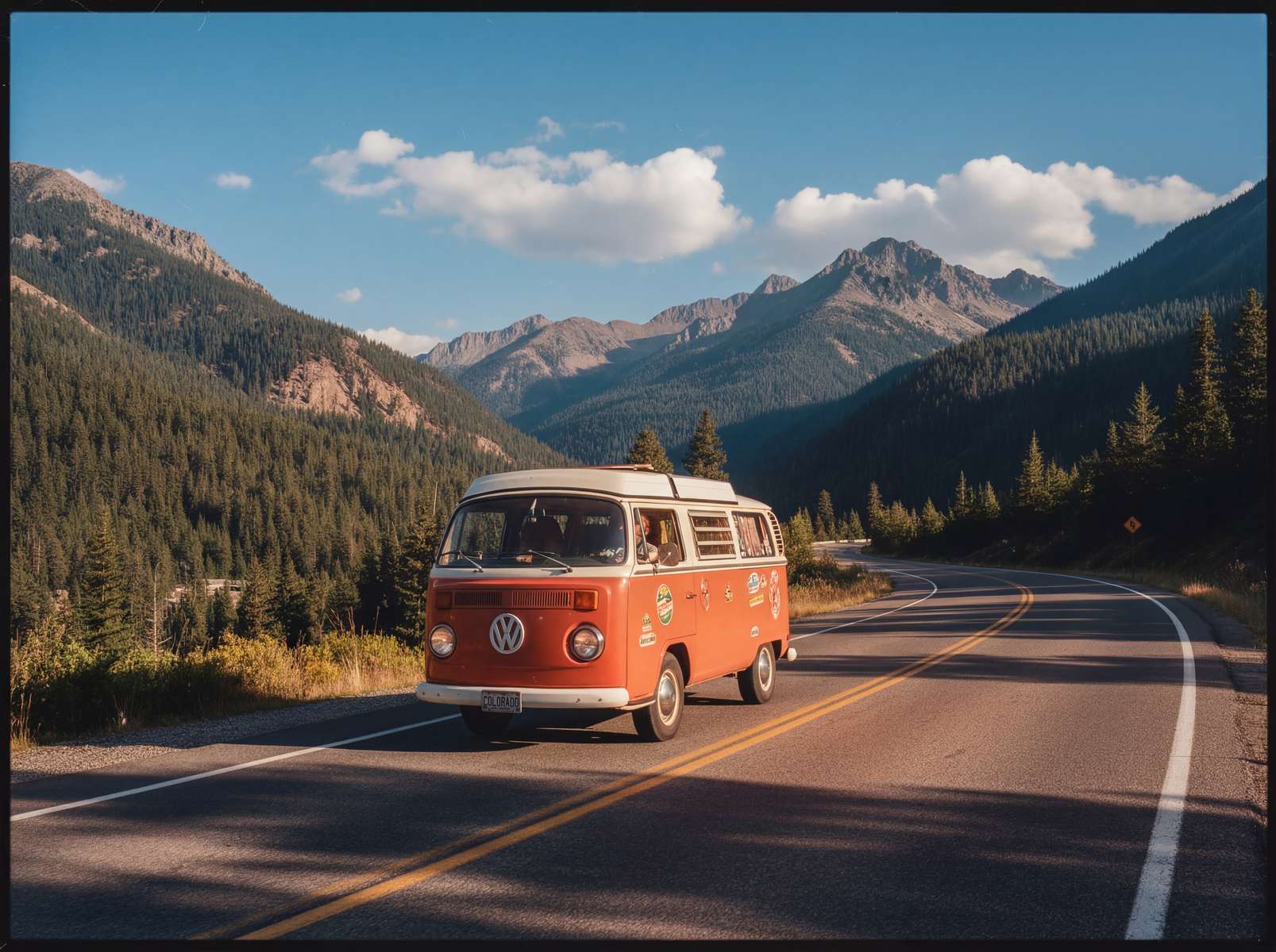 Vintage film - vintage vw camper van travelling along a road in a mountainous area